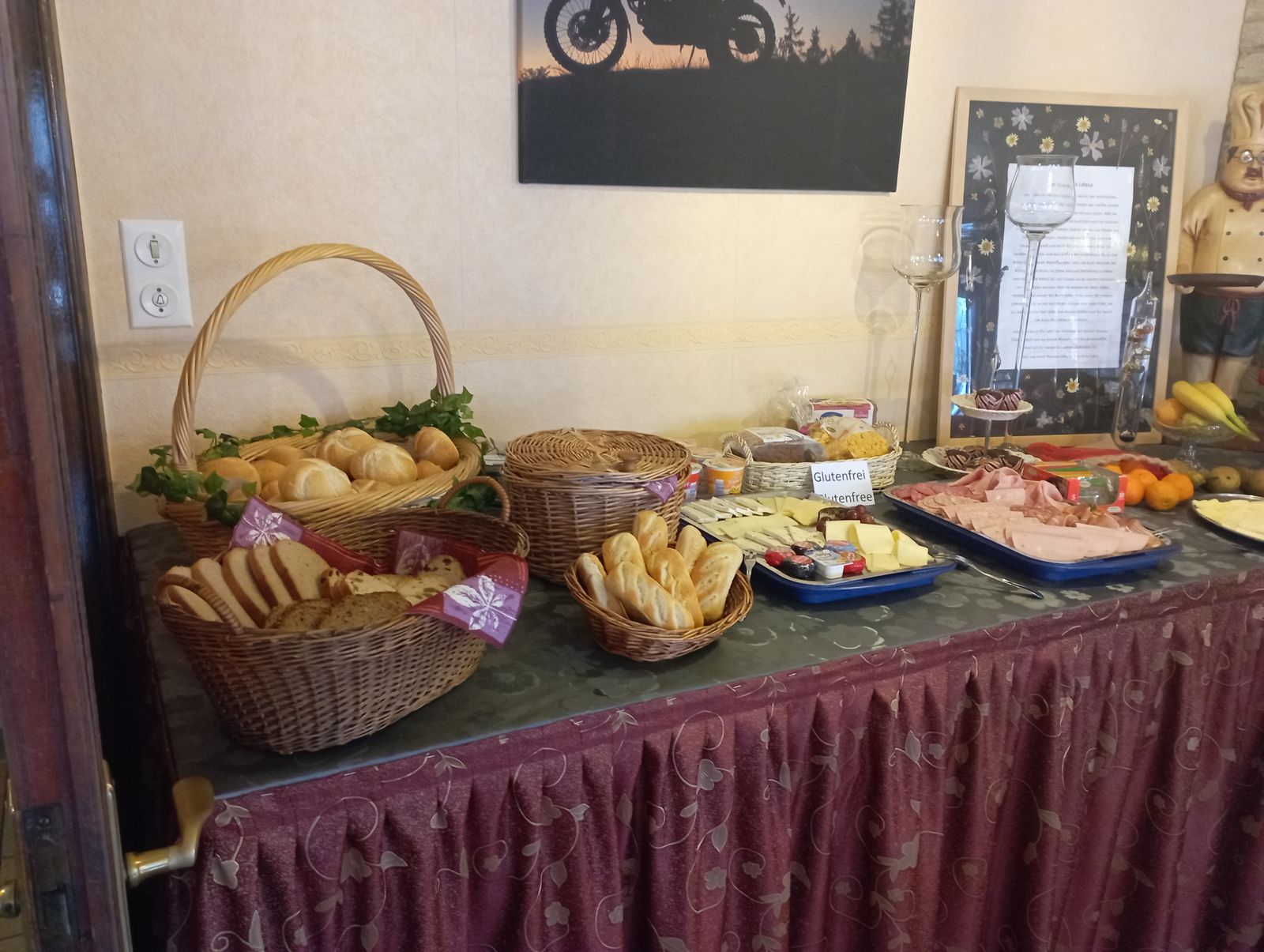 Frühstücksbüfett mit Brotkörben, Aufschnitt und Käse
